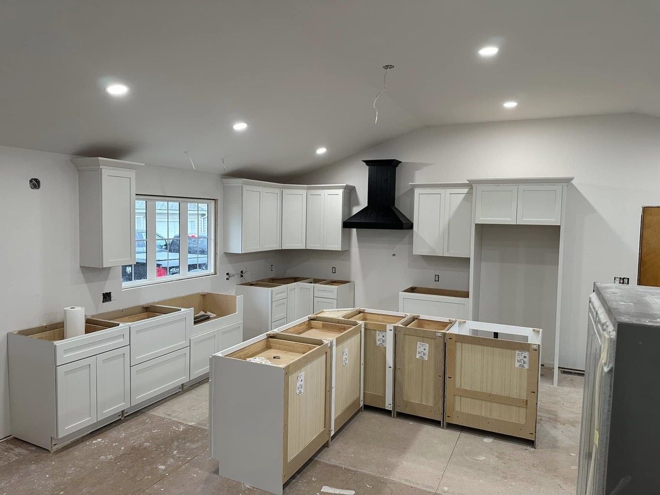 Custom kitchen with white cabinets and black range hood