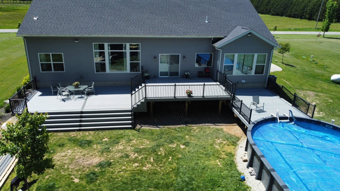 Multi-level composite deck on a gray ranch home
