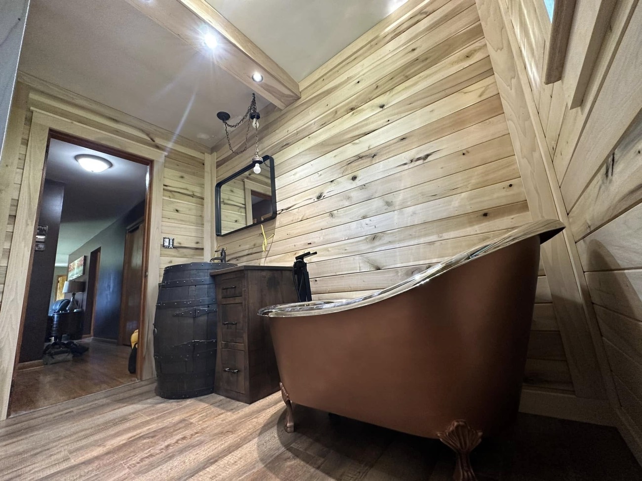 Rustic bathroom with pine shiplap walls and a copper slipper tub