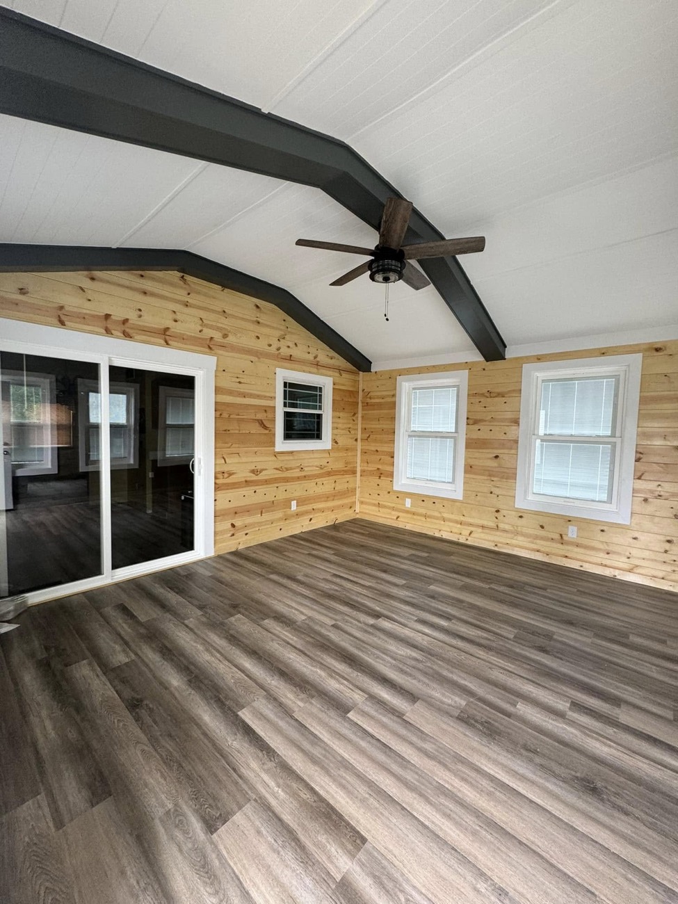 Three-season sunroom with pine walls and beamed ceiling